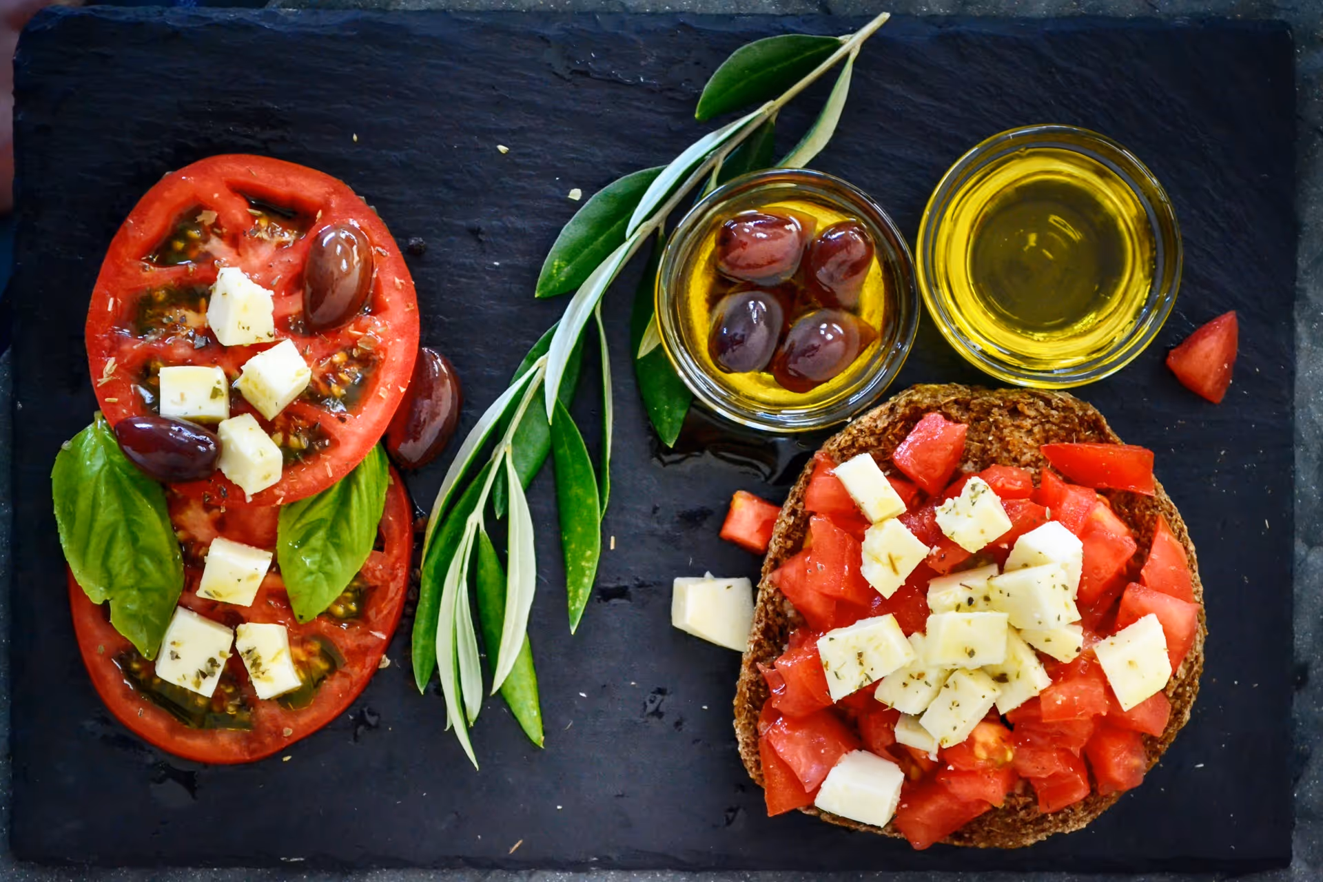 Tomate, Käse, Brot, Oliven, Olivenöl und Kräutern