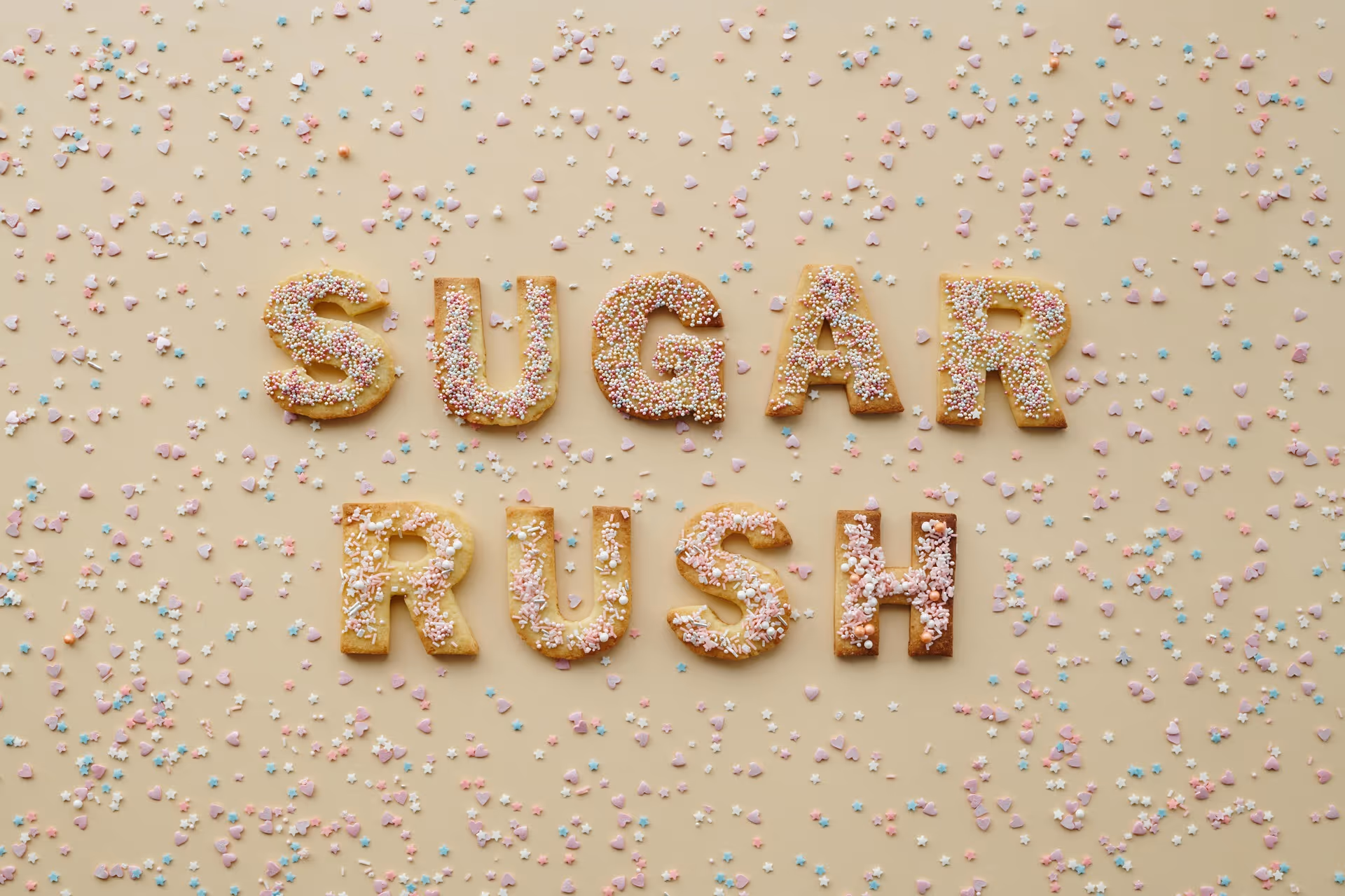 "SUGAR RUSH" spelt in cookies letters in a sea of sprinkles
