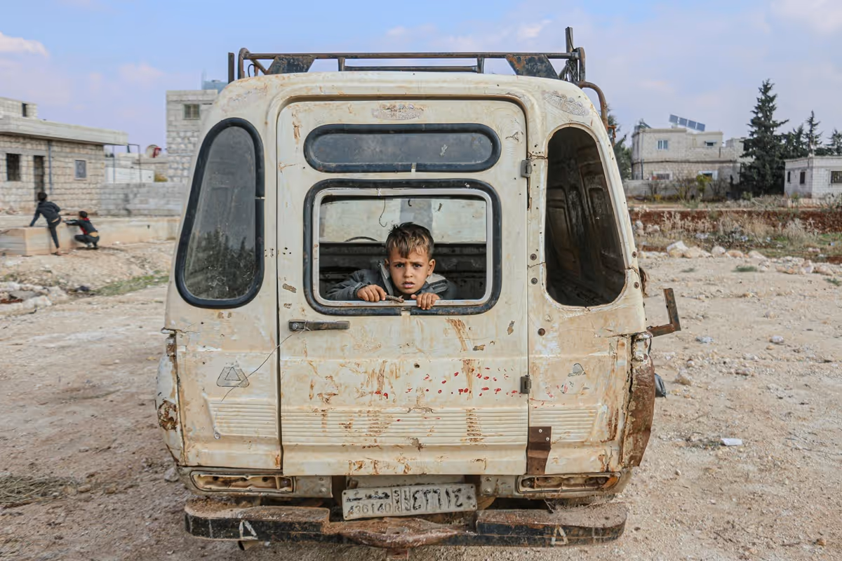 Young boy at the back of a van in a Syrian warzone