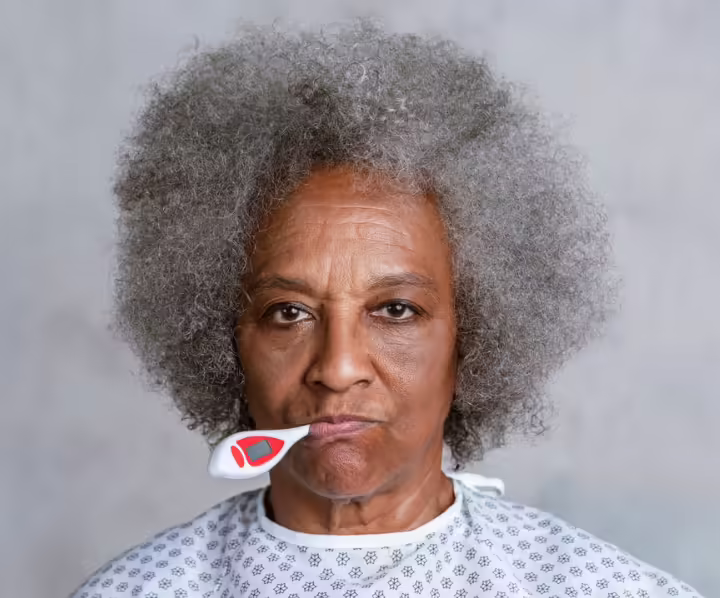 ältere Frau mit Thermometer im Mund