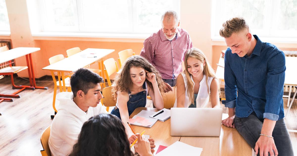 group of students planning a wellbeing initiative with a teacher