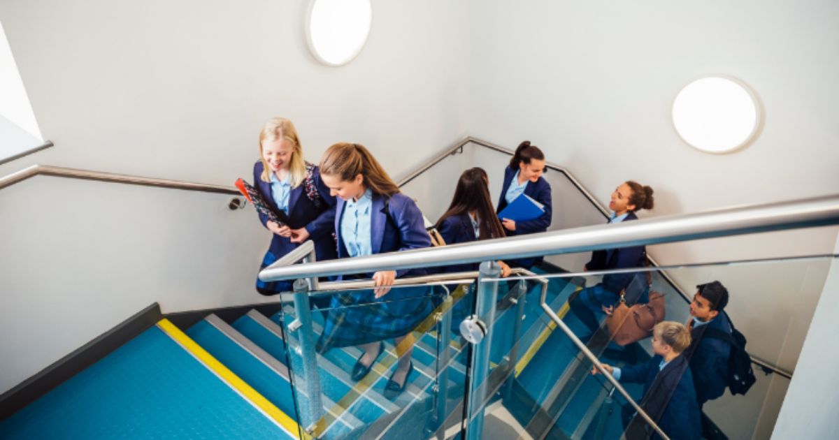Students walking up the stairs to their next lesson, chatting and smiling
