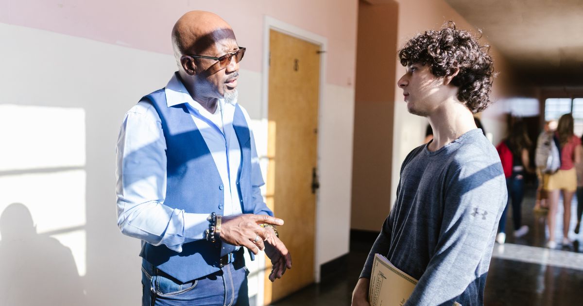 male SENDCO having a coaching conversation with a student in a school corridor post 16 setting