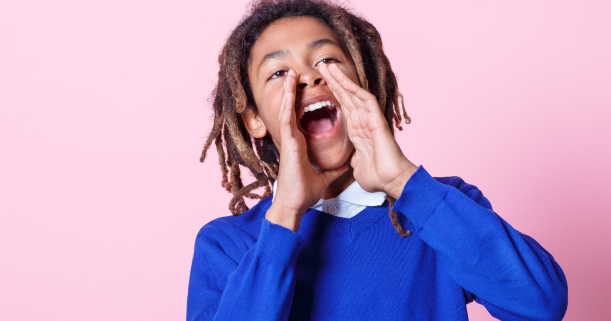 Pupil with hands around his mouth shouting, indicating the importance of his voice in whole school wellbeing and belonging