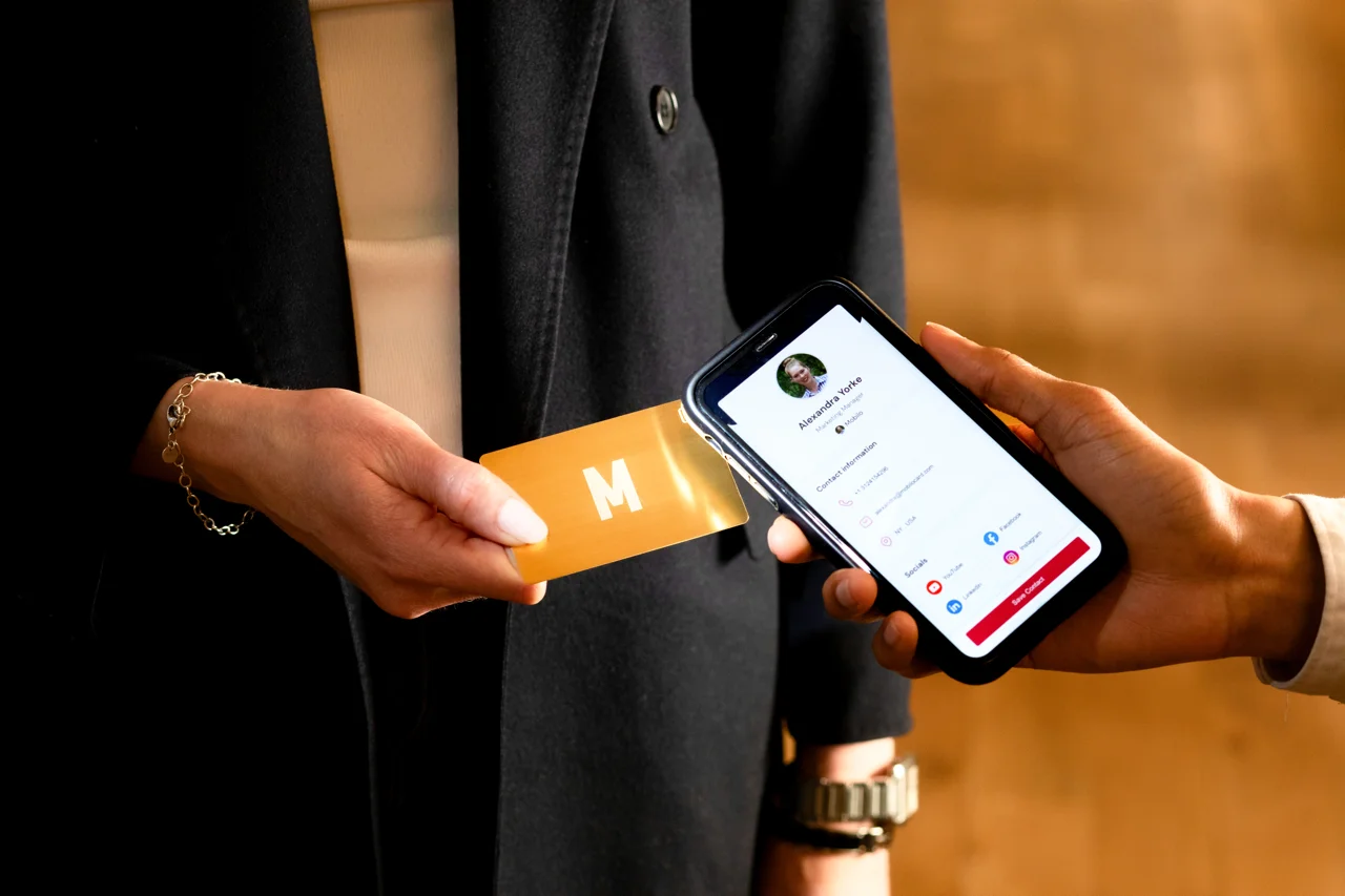 Taping a Gold metal Mobilo business card on phone. Phone screen showing the contact details that opened after the NFC transfer