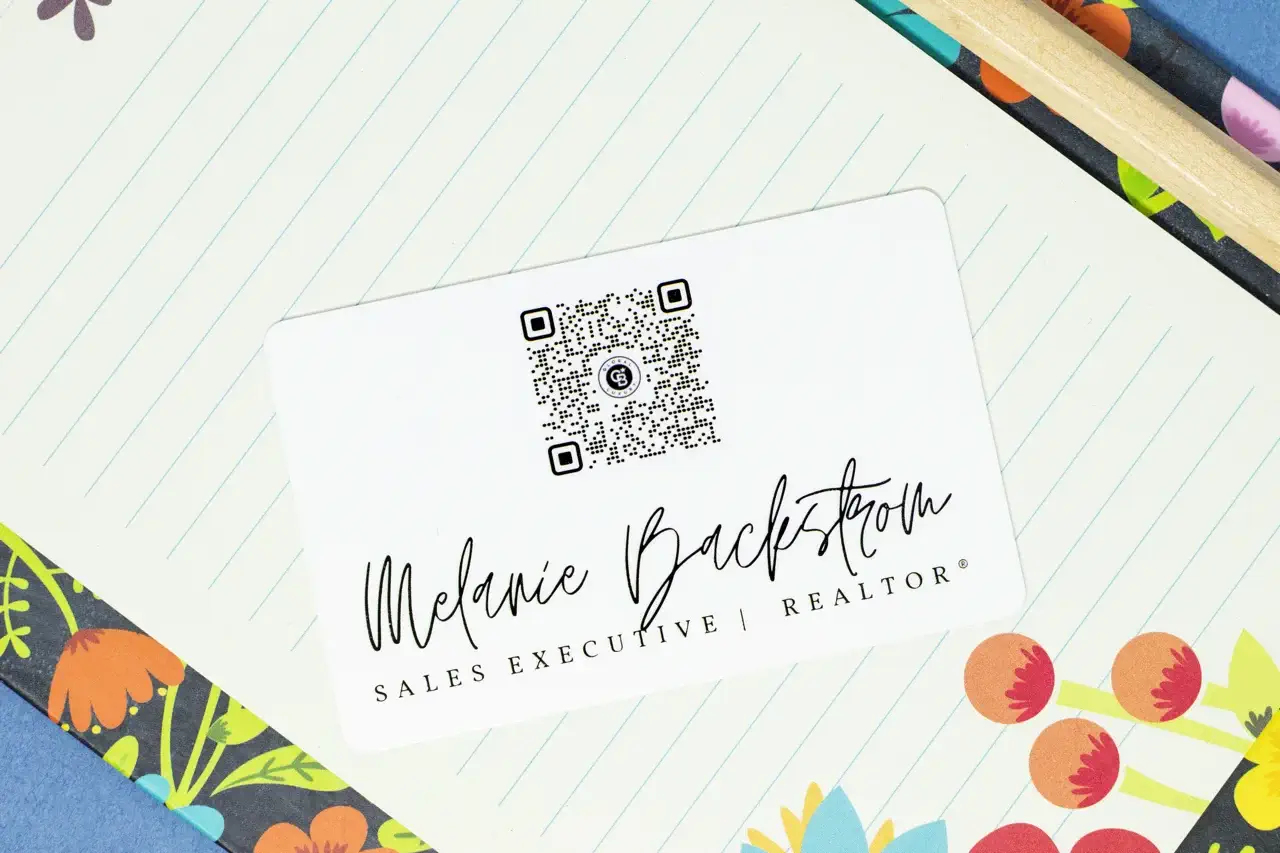 A white business plastic NFC card with a square QR code customized with the brand's logo