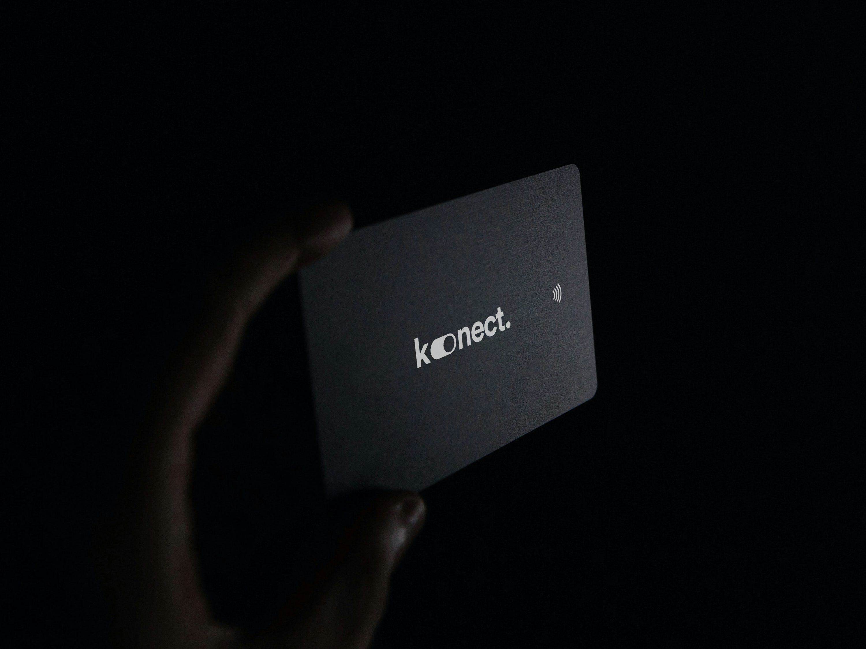 a person holding up a business card in the dark - Digital Sales Transformation