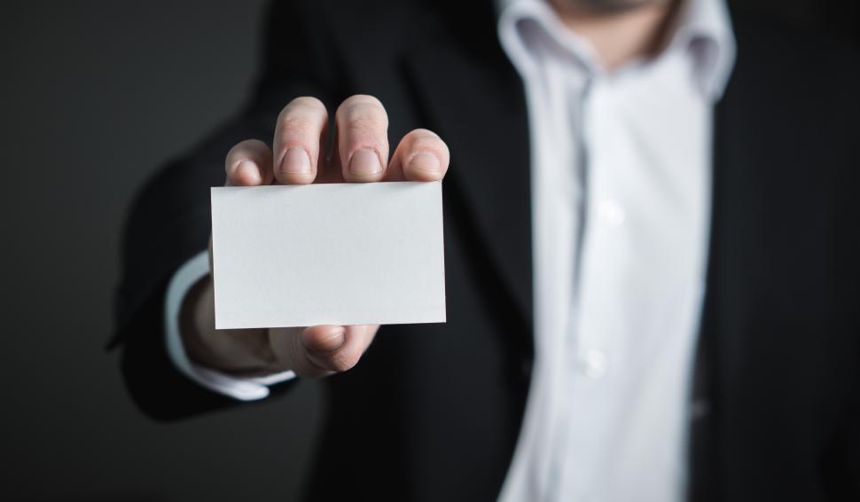 man holding a blank business card - How to Make Your Business Card Stand Out