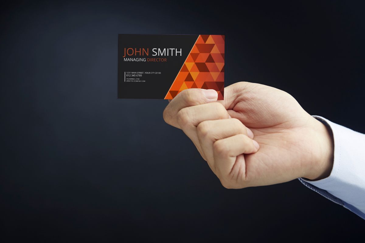 man holding a business card - How to Make Your Business Card Stand Out