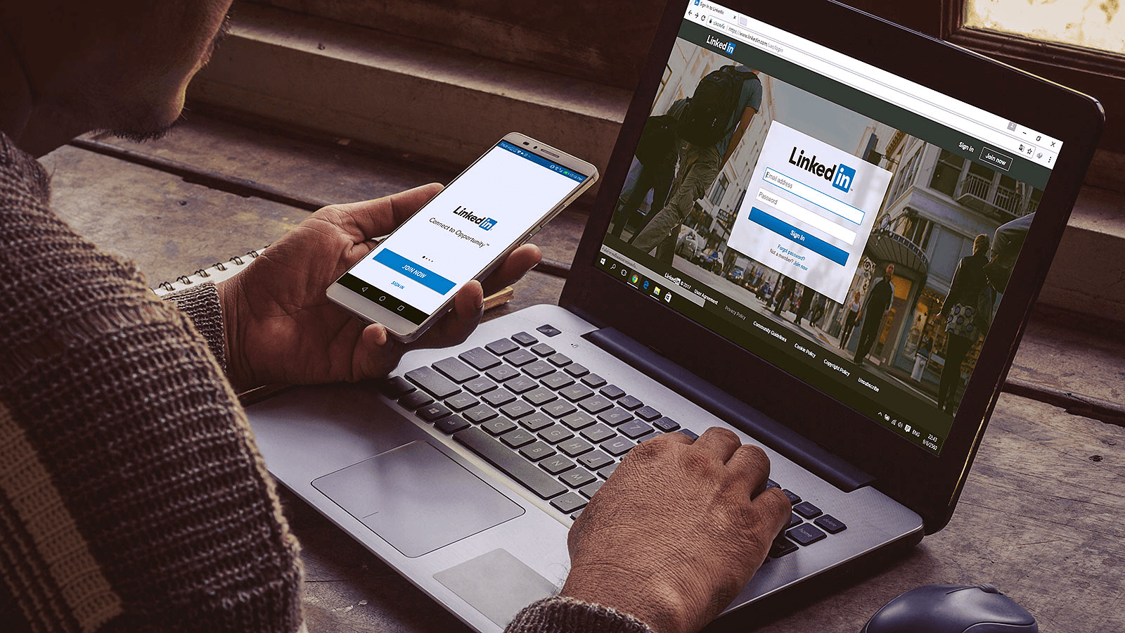 Man using LinkedIn on laptop and smartphone - How to Add Website Link to LinkedIn Profile