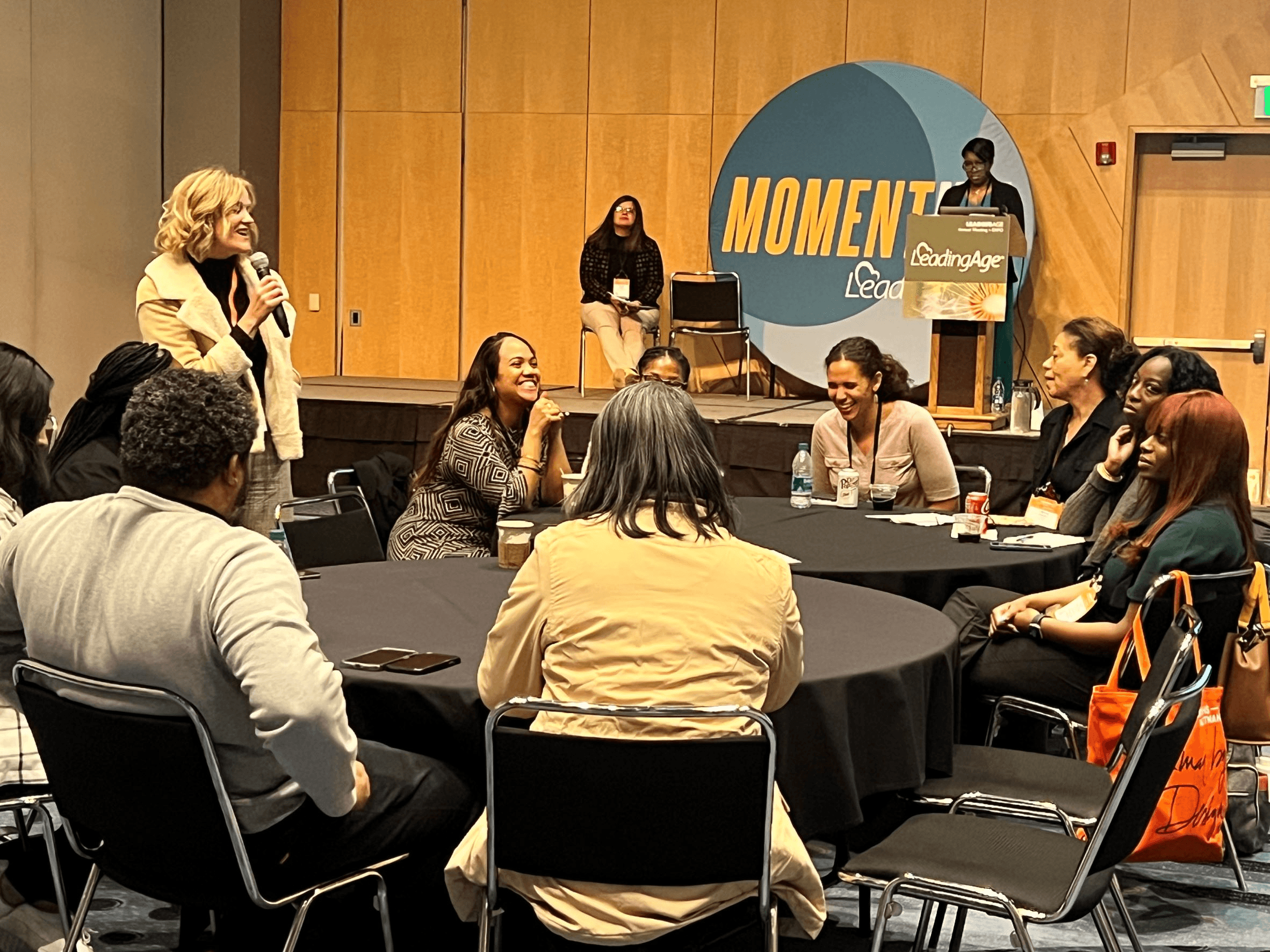 Woman speaking to round-table conference audience -  Networking Activity Ideas for Conferences