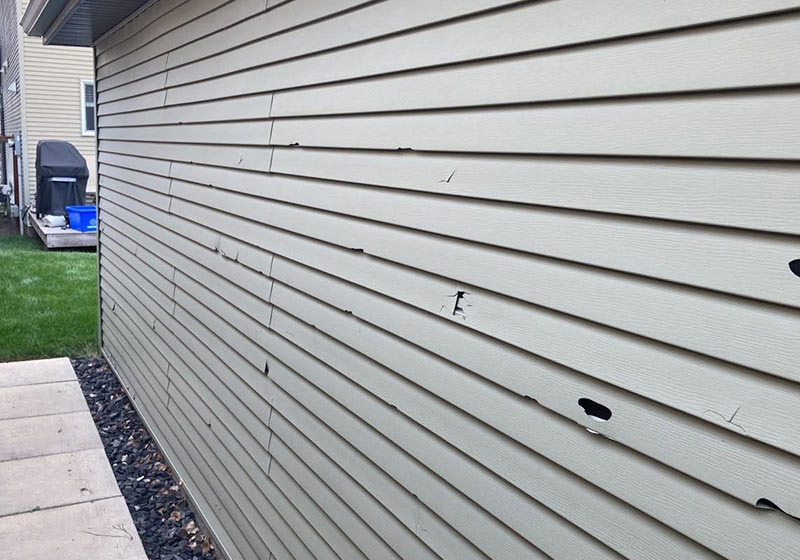 Vinyl siding on a Calgary home with hail damage