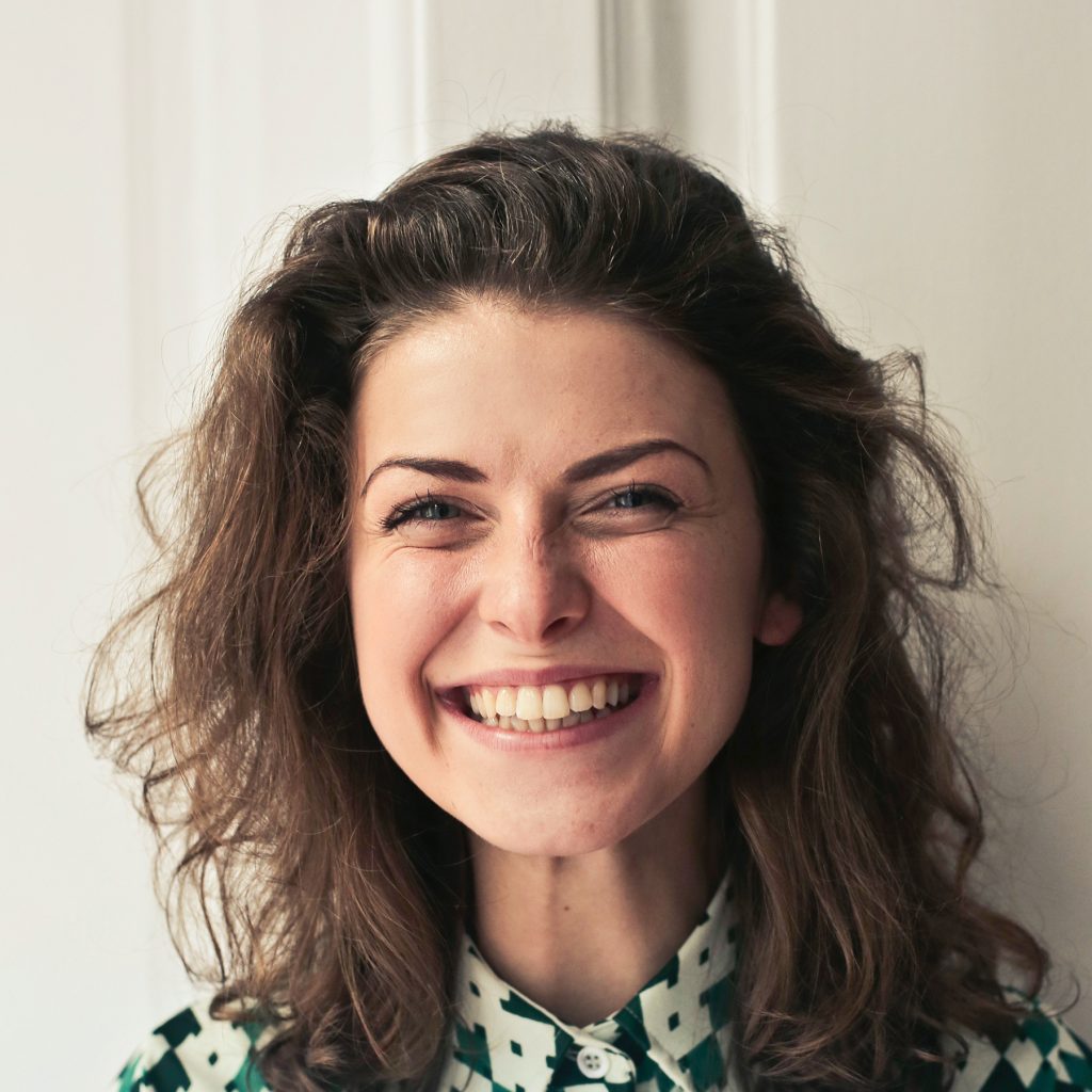 A placeholder avatar of a young woman smiling big.