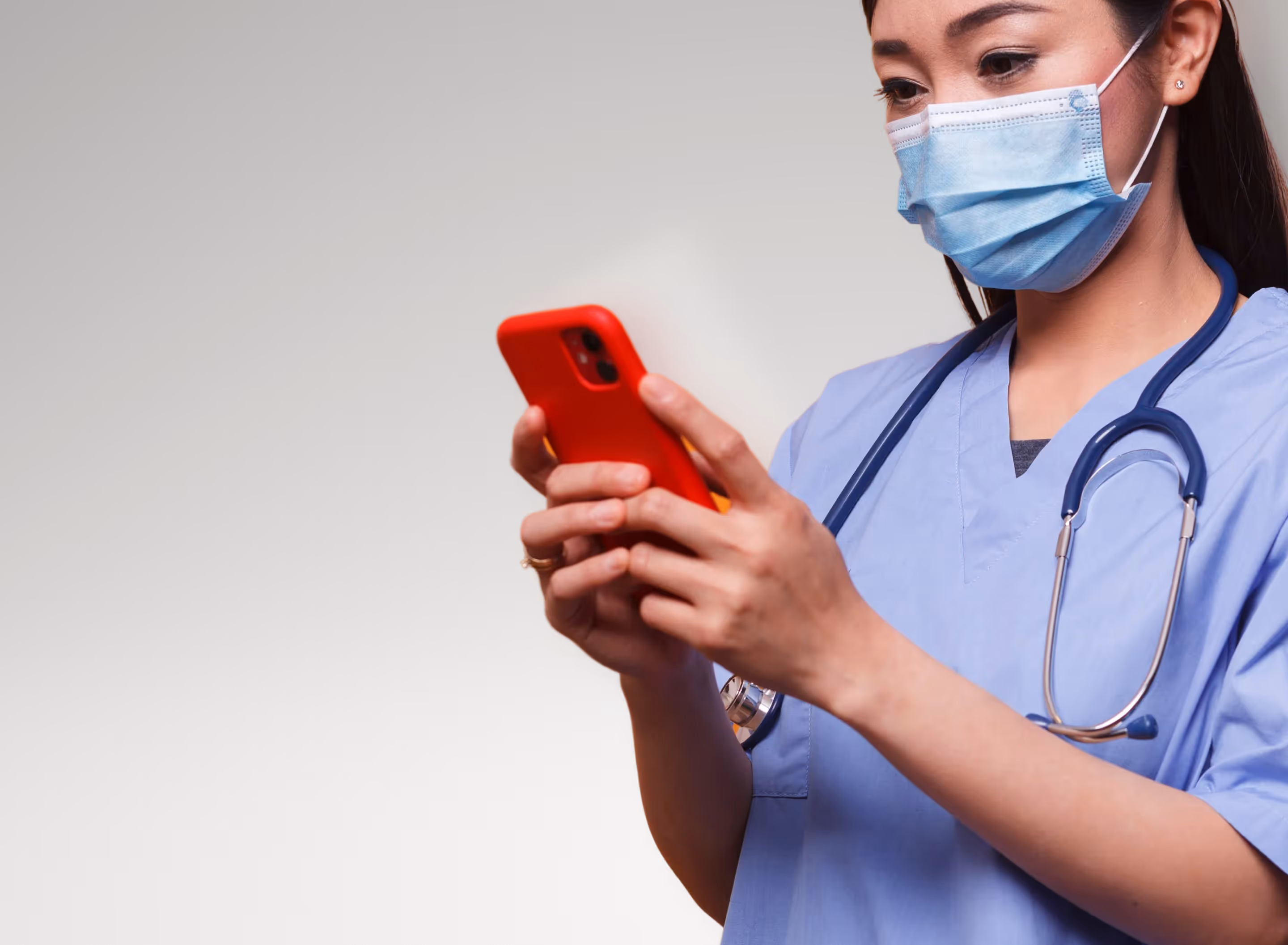 Nurse using a phone to check the Osso VR press articles