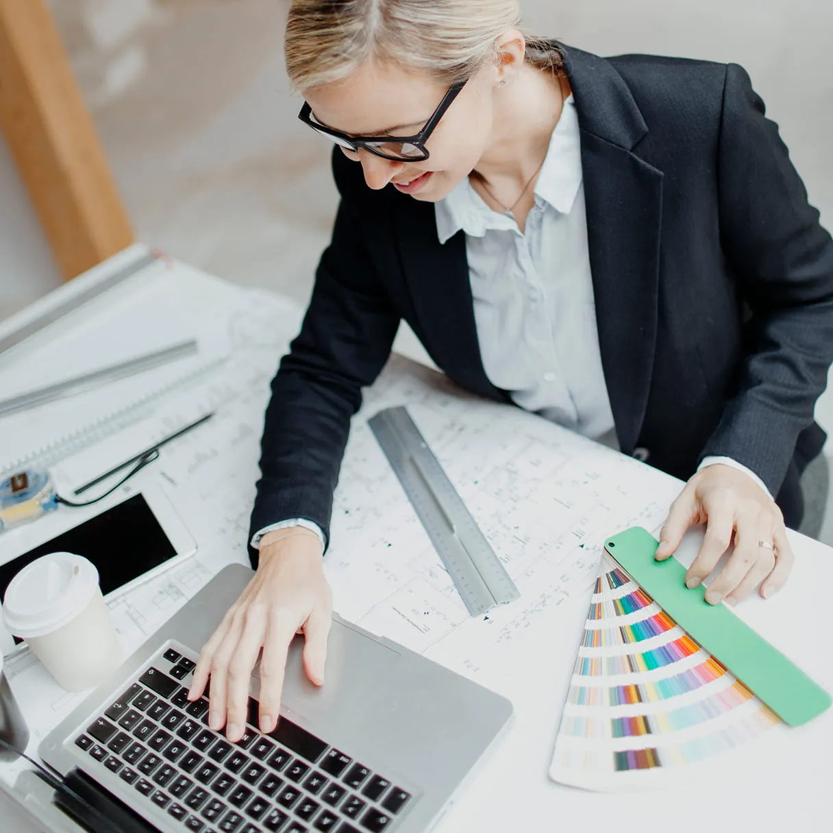 A woman sitting at a table working on a laptop.