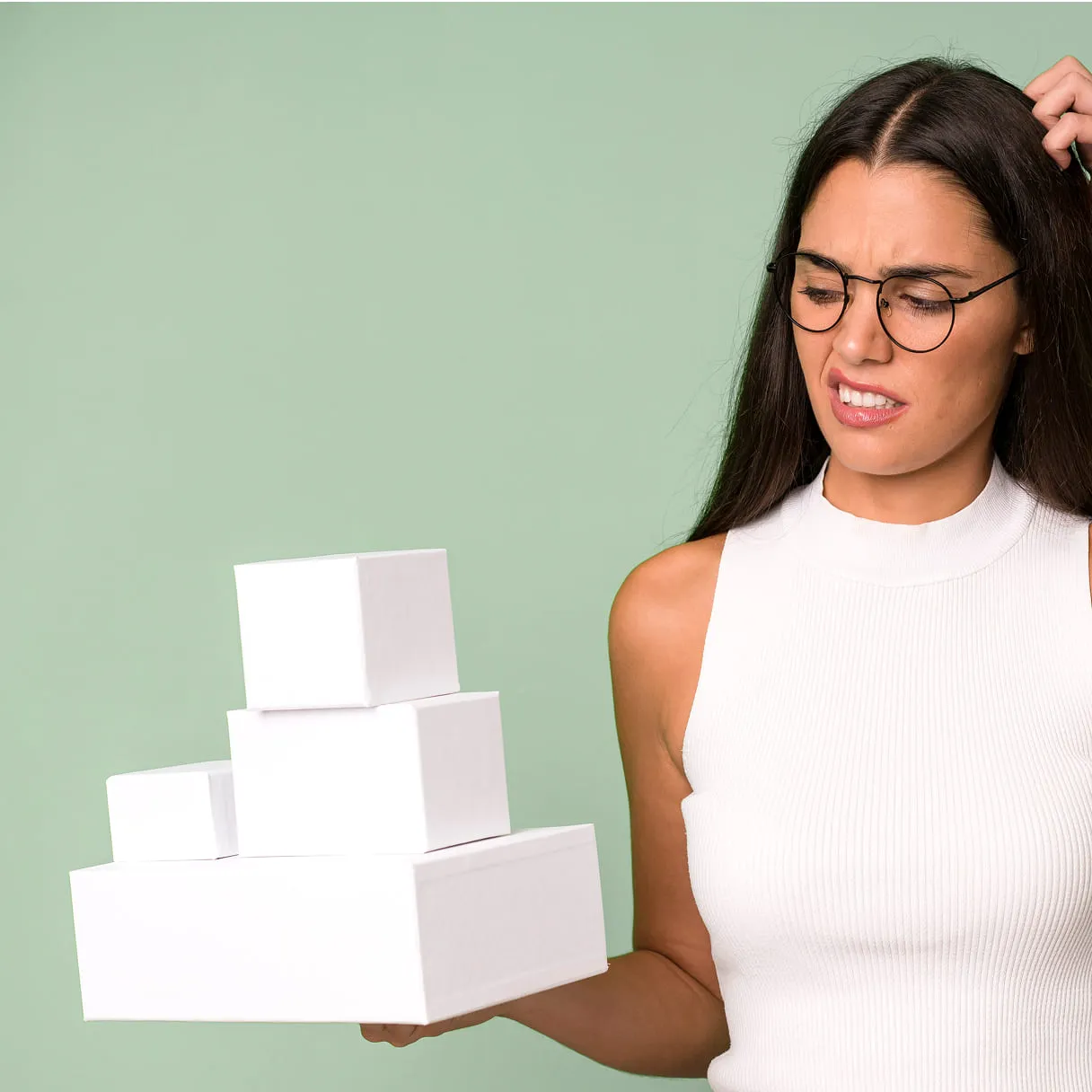 A woman holding a stack of white boxes.
