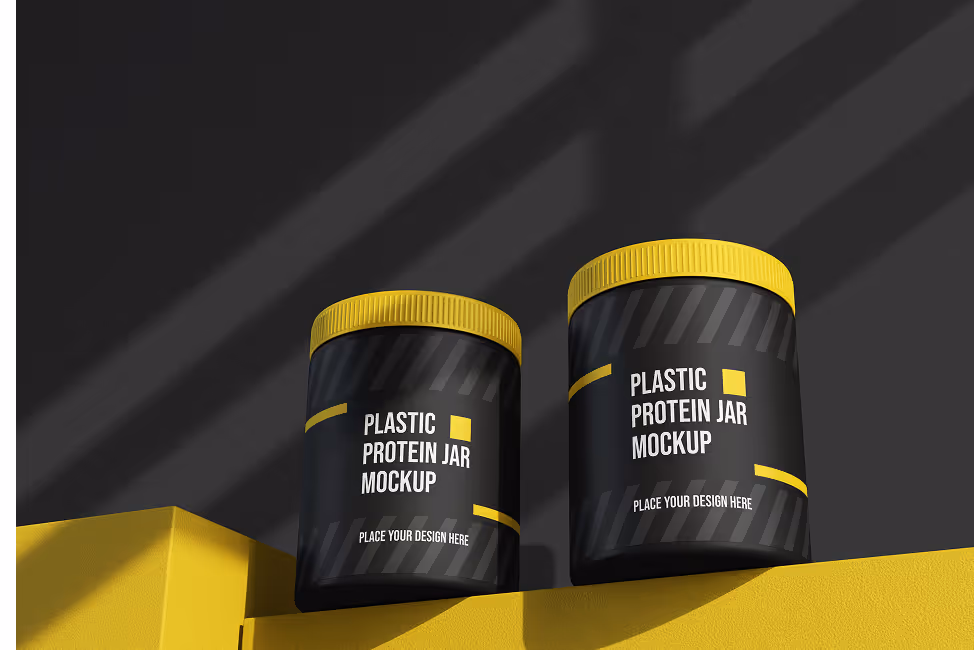 Two black plastic protein jars with yellow lids on a yellow surface against a dark background with diagonal shadows.