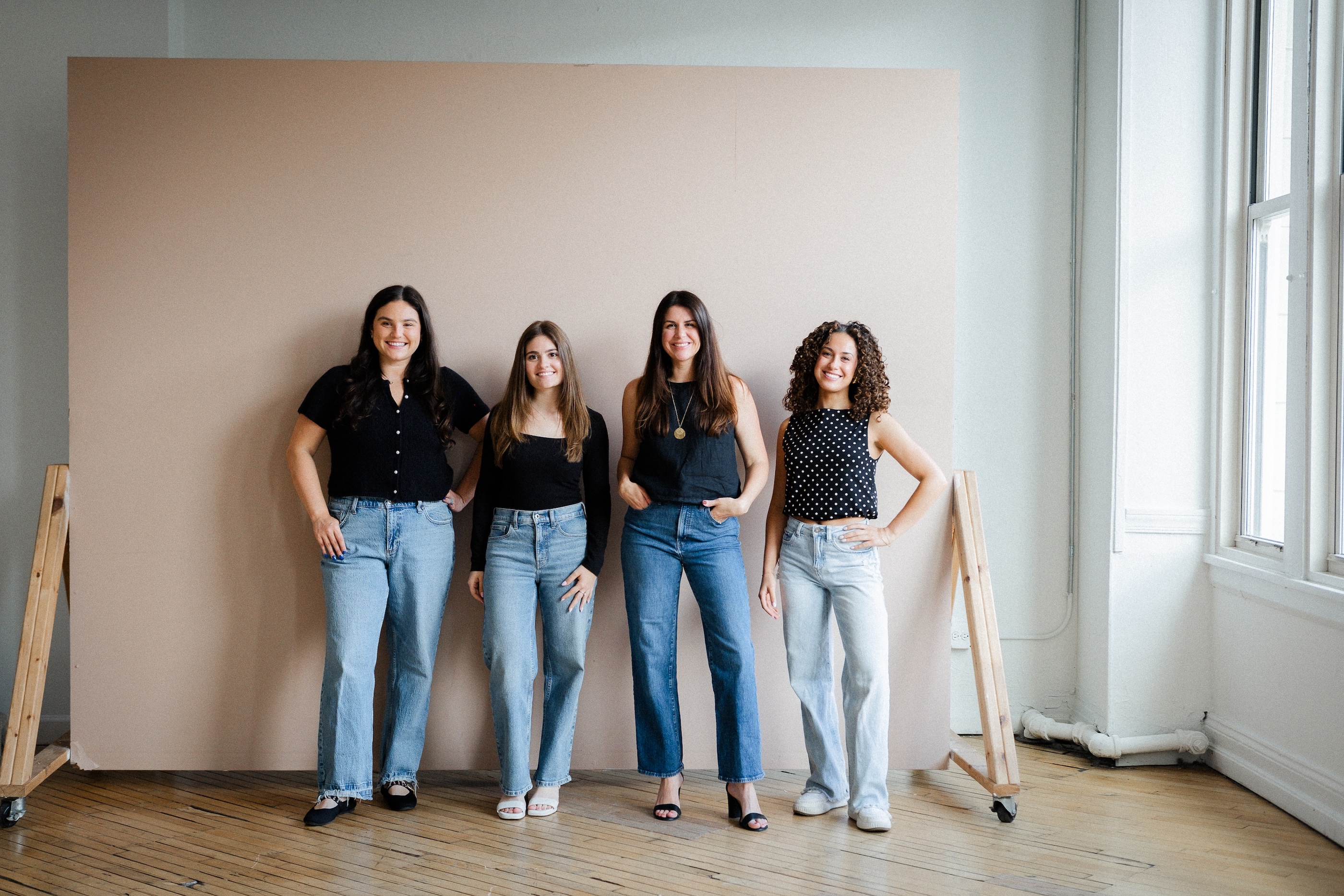 the jamtik marketing team in front of a chicago mural in logan square. Sydney onoyan is on the left, Elizabeth Smith in middle and Danielle Young is on the right. All three women are smiling and wearing jeans and a casual top. 