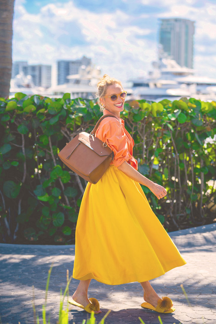 Woman in a yellow dress walking near lush greenery at the Marina.