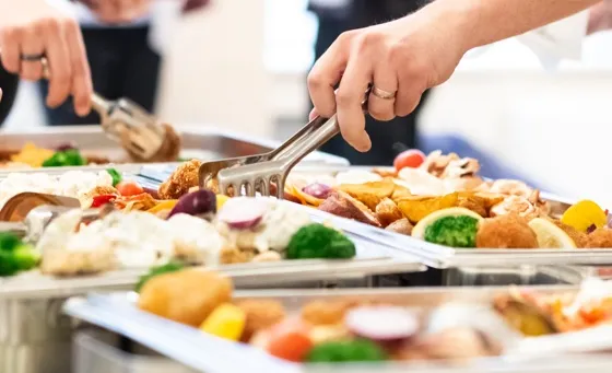 People serving food from catering line