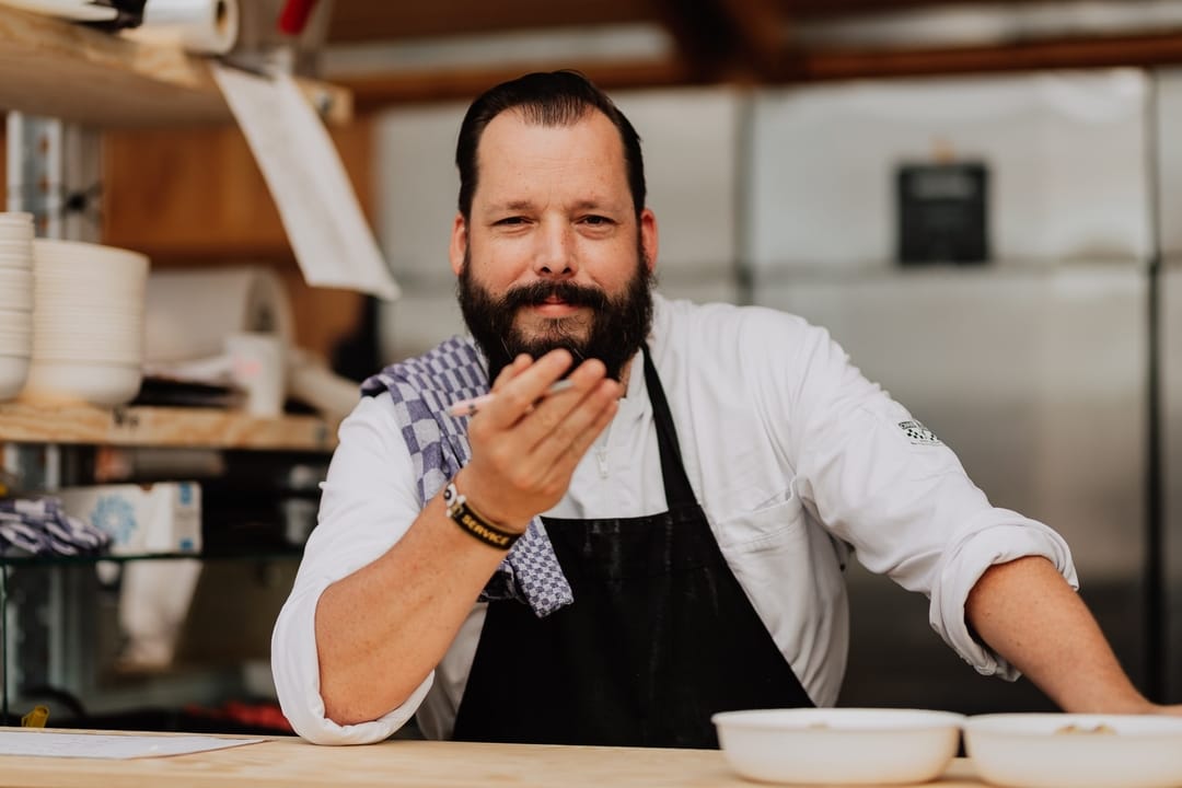 chef kijkt trots de camera in