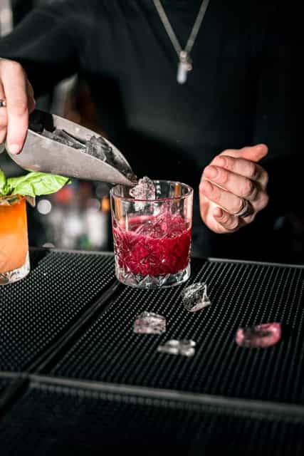 Bartender making a strawberry drink with ice