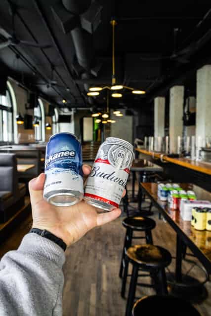 Man holding two cans of beer in one hand