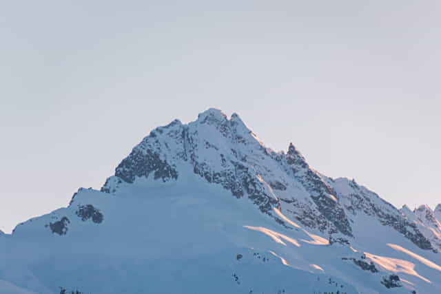 Light shining on parts of snow covered mountains