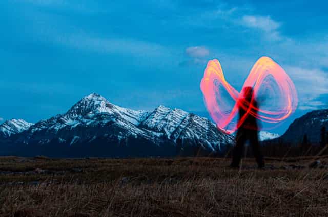 Long-exposure light drawing an infinity with mountains in the back