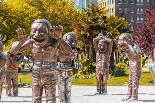 A-maze-ing Laughter statues in downtown Vancouver with palm trees behind