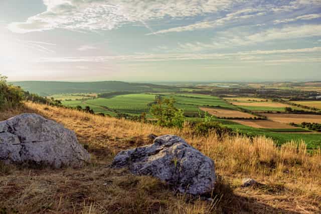 Landscape of farms and fields with rocks in the foreground