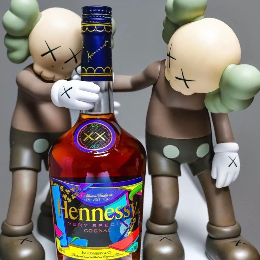 Bouteille Hennessy Very Special habillée par l'artiste KAWS, entourée de deux de ses figures emblématiques