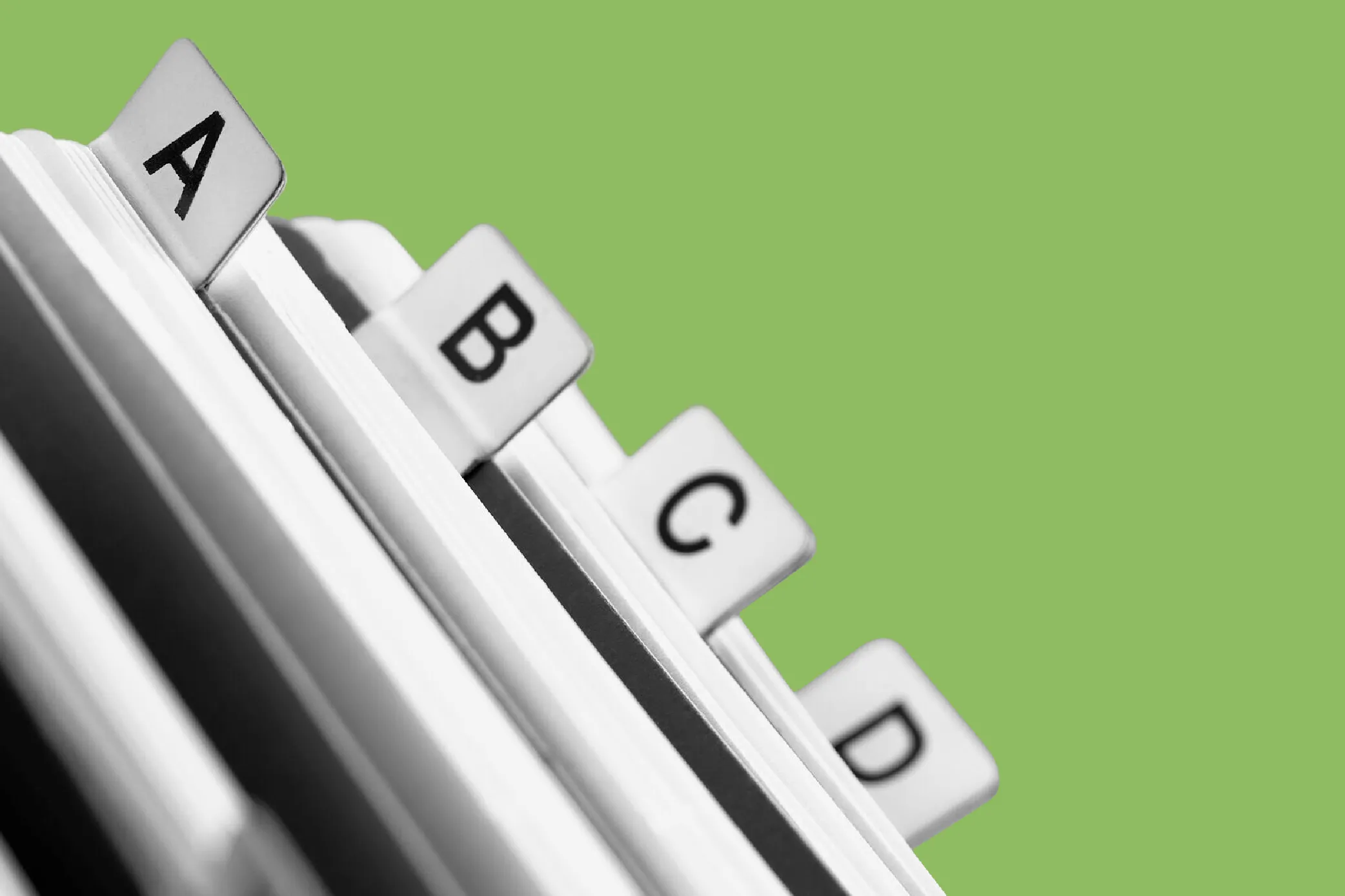 Close-up of a folder with tabs labeled A, B, C, and D against a green background.