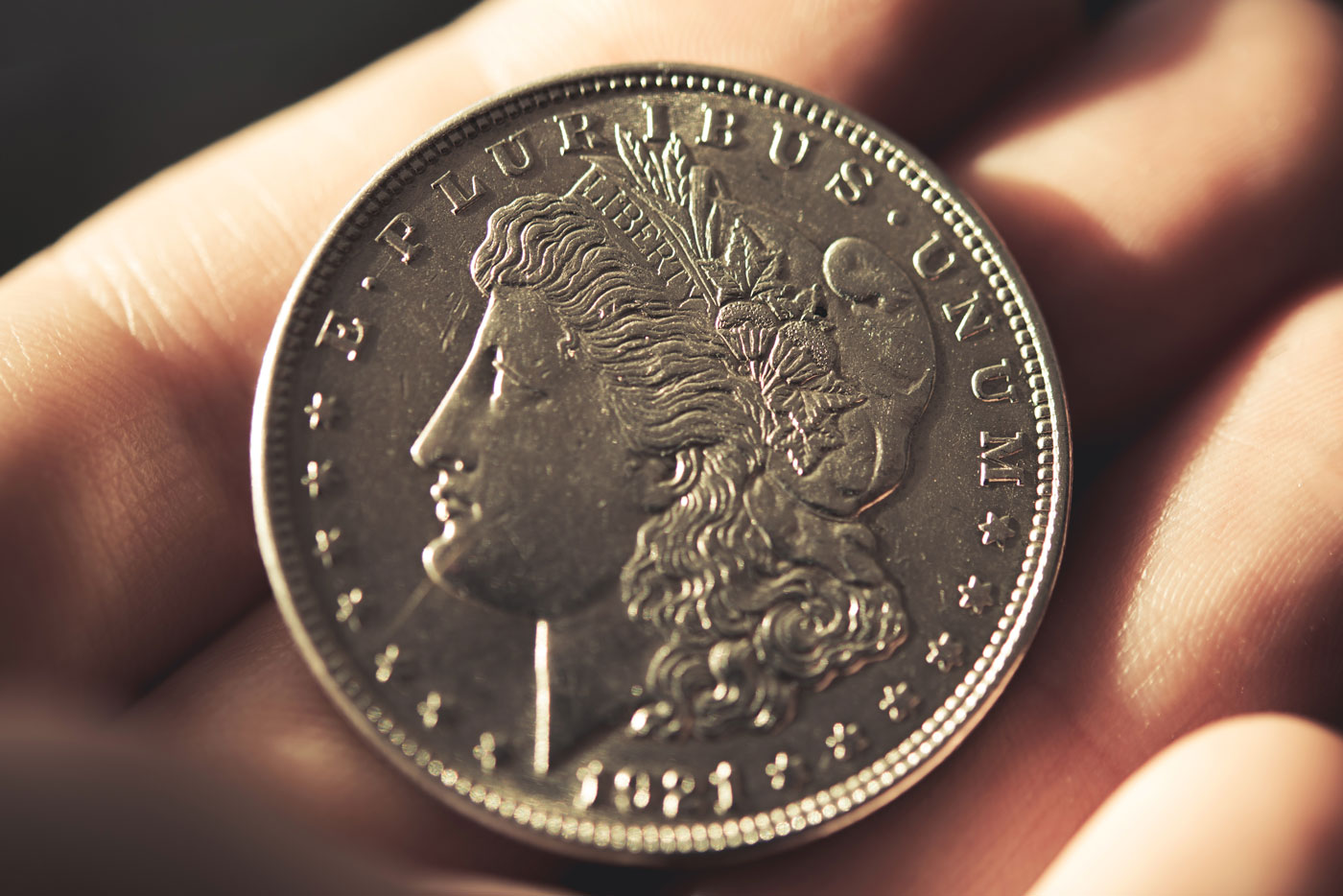 Closeup of a Morgan Silver Dollar for sale in an investor’s hand