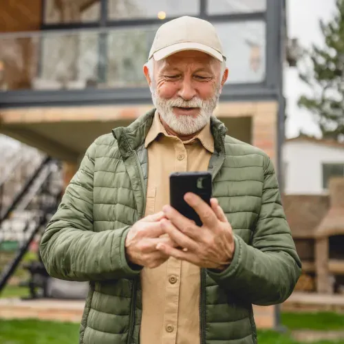 A man smiling while looking at the phone