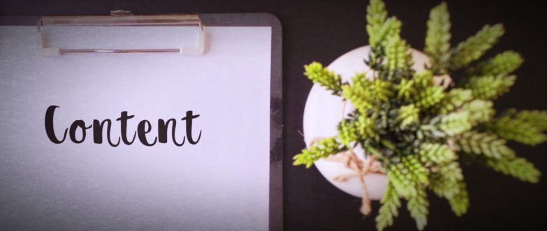 Notebook with the word ‘Content’ next to a plant on a desk.
