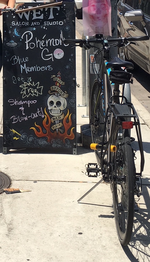 Storefront chalkboard promoting Pokémon-themed specials next to a bicycle.