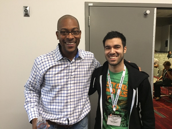 Two people smiling for a photo at a conference.