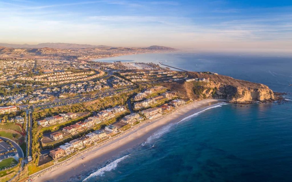 Aerial view of California coast and Dana Point harbor in Orange County on a sunny day.