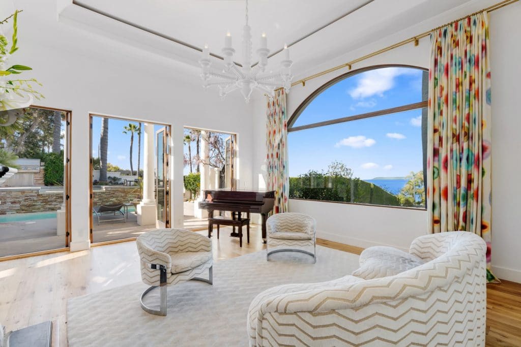 Living room with ocean views opening to luxurious backyard