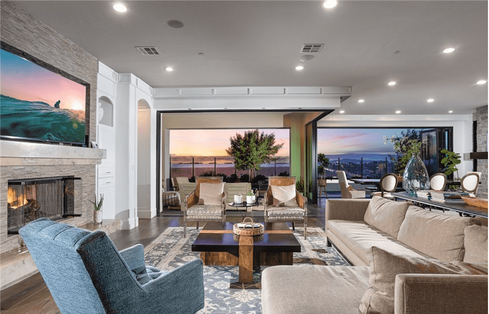 Open concept modern home with open pocket doors leading to backyard with ocean views