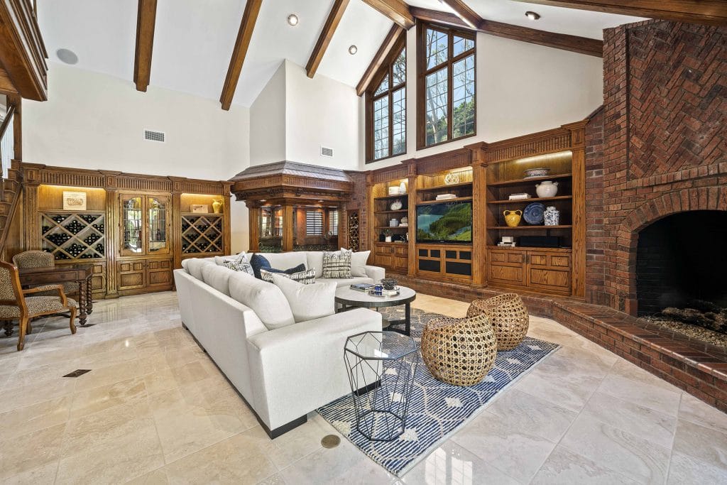 Living room with high vaulted, wood beamed ceilings, custom brick built-ins and wet bar