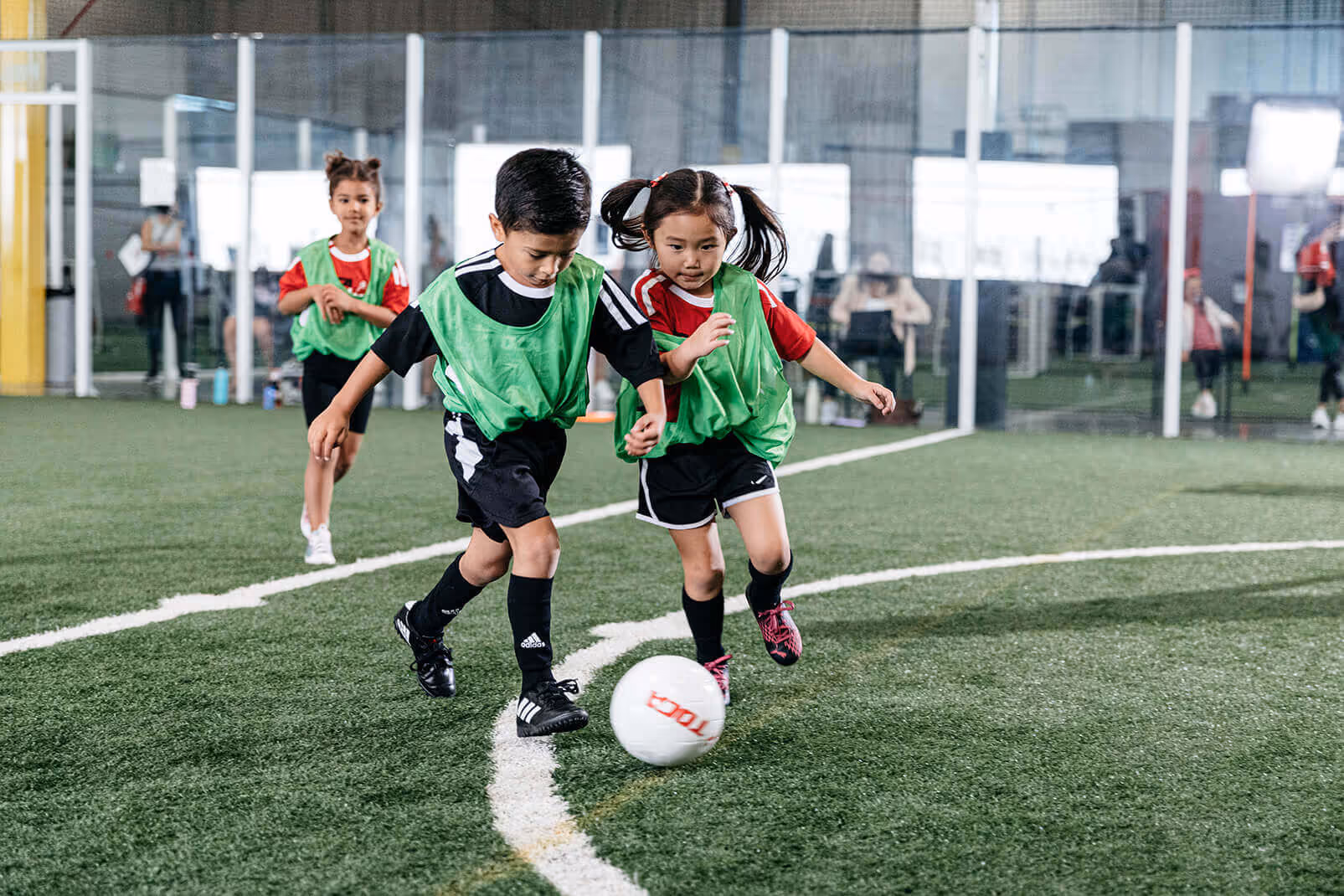 Kids playing soccer at a TOCA soccer center.