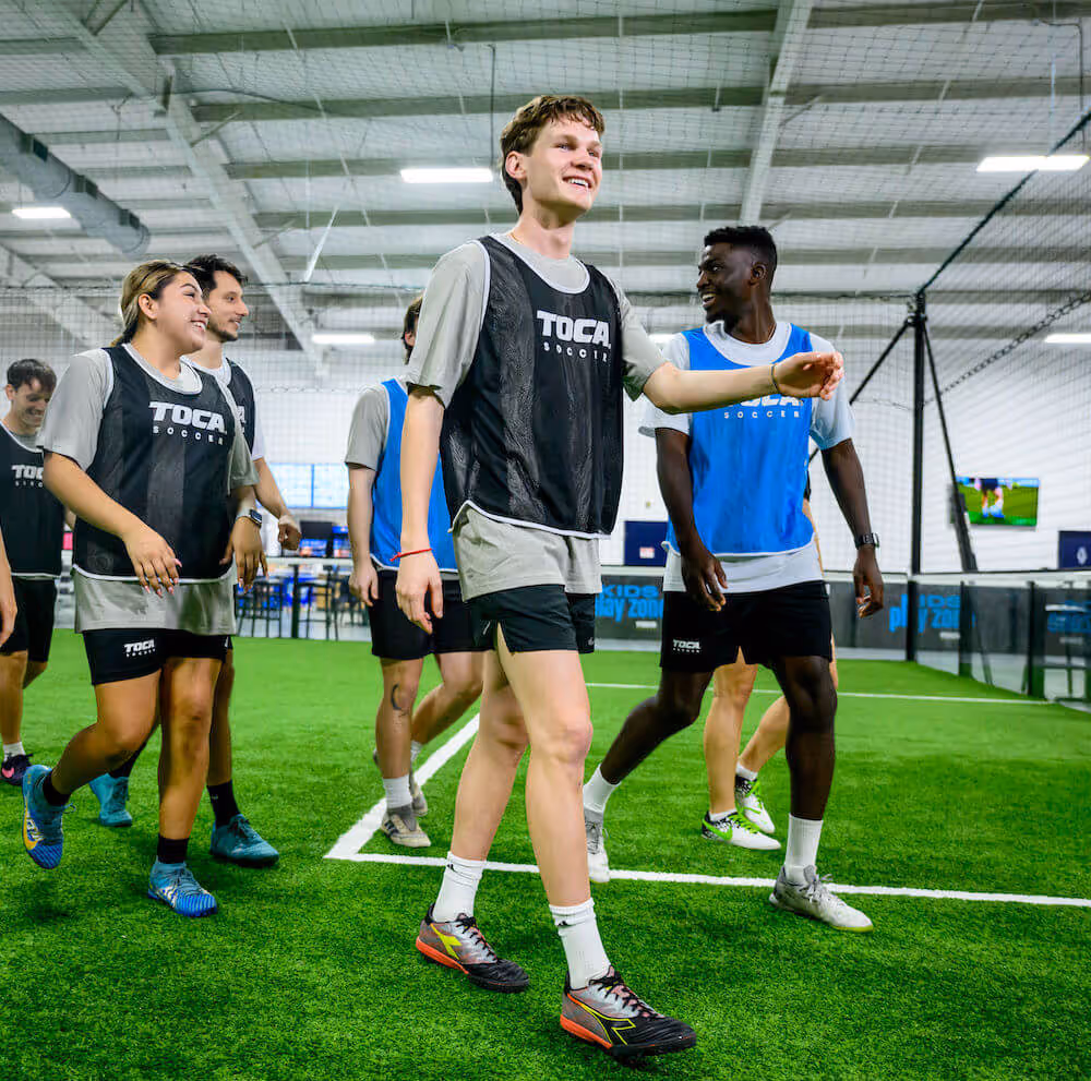 Pickup Soccer teammates walking on indoor soccer field.
