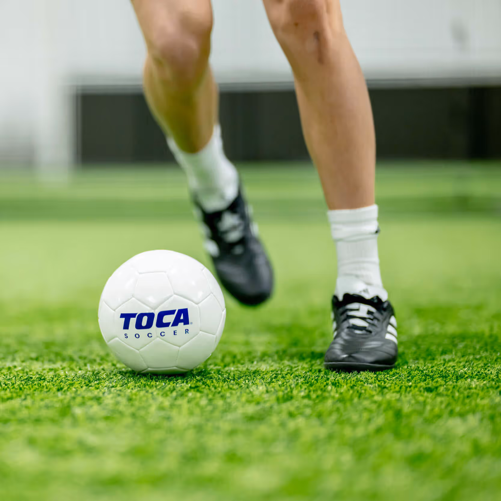 TOCA soccer player kicking a soccer ball.