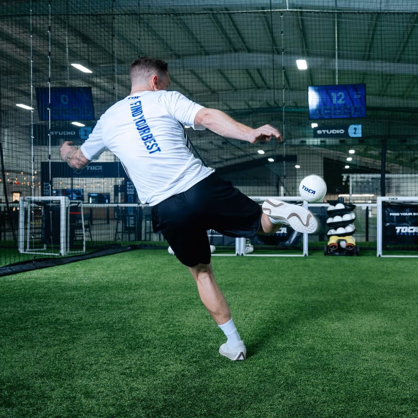 Soccer player practicing kicking the ball into technology enabled goal.