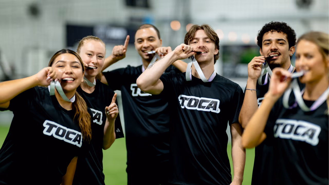 Adult soccer team celebrating with medals at TOCA Soccer tournament