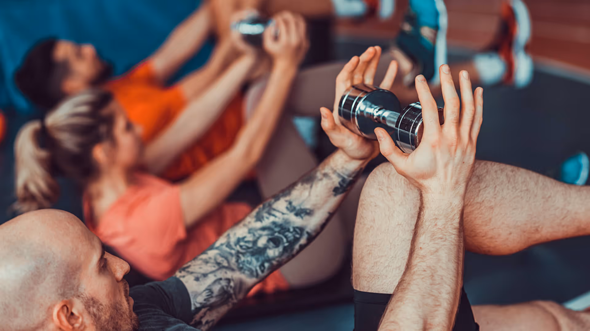 A group of people in a fitness class lifting weights.