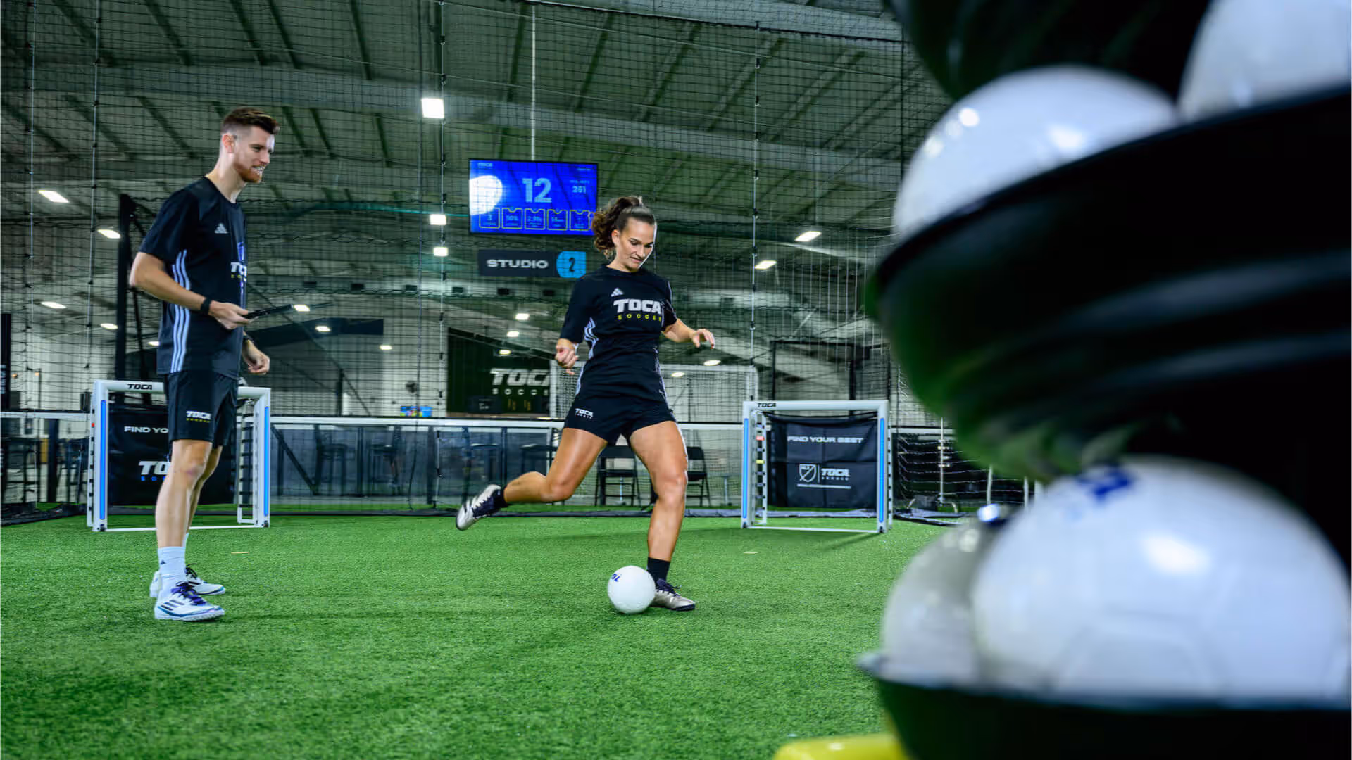 Soccer player in private training session at TOCA, practicing with Smart Targets under the guidance of a coach on an indoor soccer field.