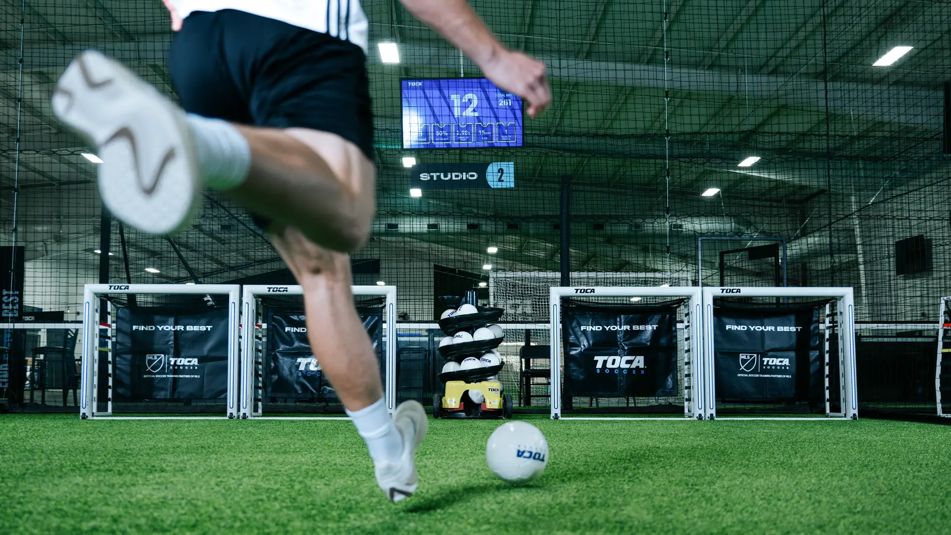 Soccer player striking a ball during a private training session on indoor turf at TOCA Soccer